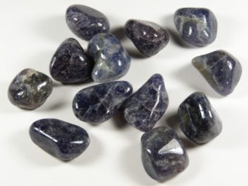 Kilka wypolerowanych kamieni szlachetnych leży na białym tle.