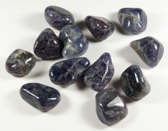 Kilka wypolerowanych kamieni szlachetnych leży na białym tle.