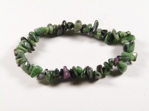 Bransoletka z zielonych i fioletowych kamieni na białym tle.