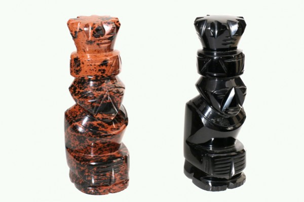 Dwie rzeźby szachowe o geometrycznych kształtach, wykonane z czarnego i brązowego kamienia.