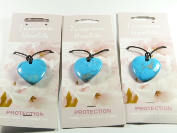 Trzy naszyjniki z turkusowym sercem na kartonikach z napisem „Turquoise Howlite Protection”.