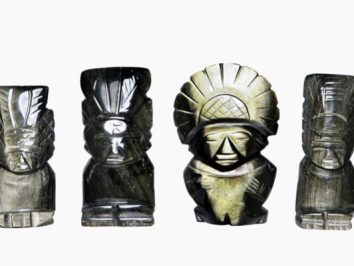 Cztery rzeźby przedstawiające postacie w pióropuszach ustawione obok siebie na białym tle.