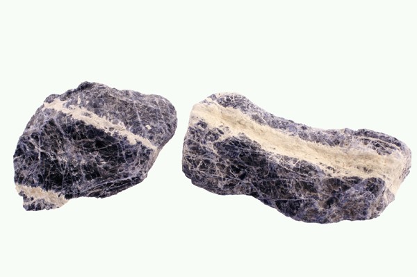 Dwa kawałki skały sodalitu z jasnym żyłkowaniem na białym tle.