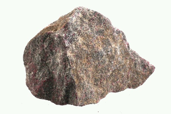 Szara bryła kamienia z widocznymi przebarwieniami na jasnym tle.