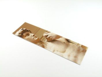 Zakładka do książki z wizerunkiem rzeźby Dawida Michała Anioła, leżąca na białym tle.