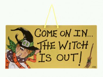 Tabliczka z napisem po angielsku i rysunkiem czarownicy oraz miotły po prawej stronie.