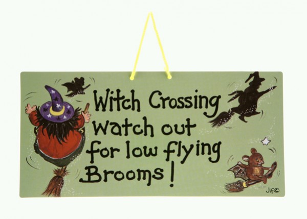 Tabliczka z napisem ostrzegającym przed nisko latającymi miotłami czarownic.