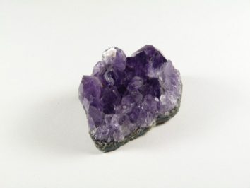 Fioletowy kryształ ametystu na białym tle.