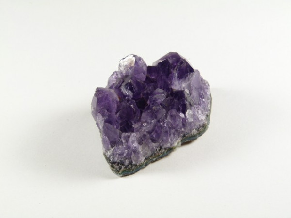 Fioletowy kryształ ametystu na białym tle.