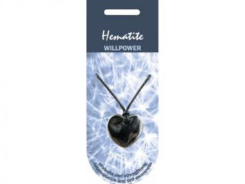 Wisiorek z hematytu w kształcie serca na czarnym sznurku, tło z jasnymi wzorami.