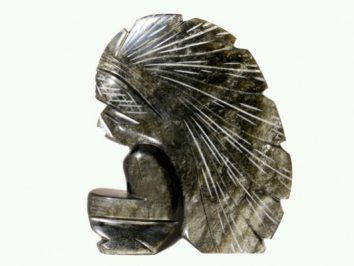 Kamienna rzeźba przedstawiająca siedzącą postać w pióropuszu indiańskim.