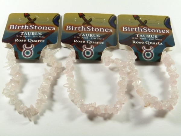 Trzy bransoletki z różowego kwarcu przypisane do znaku zodiaku Byk, na kartonikach z napisem.