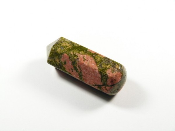 Unakit szlifowany różdżka obelisk. Różowo-zielony, oszlifowany kamień o cylindrycznym kształcie na białym tle.