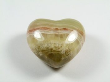 Serce onyks szlifowany. Polerowany kamień w kształcie serca, leżący na białym tle.