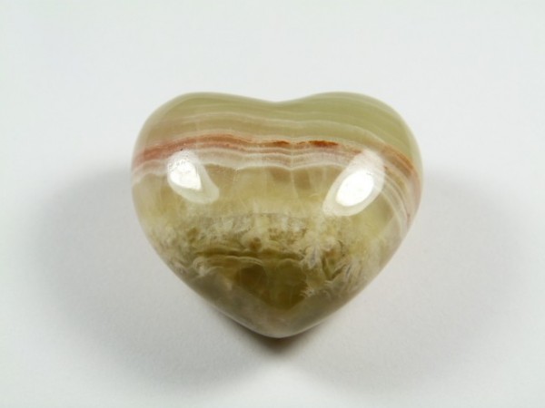 Serce onyks szlifowany. Polerowany kamień w kształcie serca, leżący na białym tle.