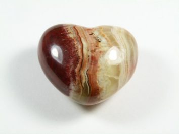 Serce onyks szlifowany. Polerowany kamień w kształcie serca z pasami w odcieniach brązu, beżu i czerwieni.