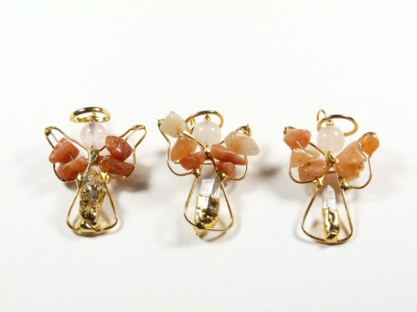 Trzy ozdoby w kształcie aniołków wykonane z drutu i kamieni, ustawione na białym tle.