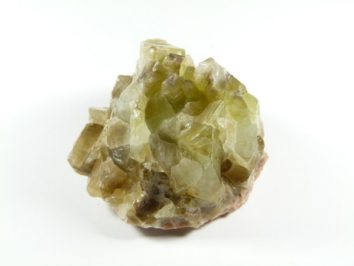 Żółtozielony kryształ minerału na białym tle.