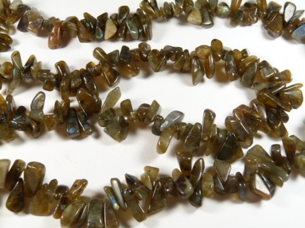 Naszyjnik z brązowych, nieregularnych kamieni ułożonych na białym tle.