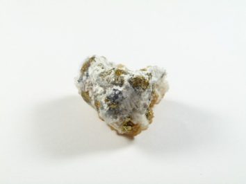 Syderyt - kamień naturalny, surowy, nieszlifowany. Biało-szary minerał z żółtymi i ciemnymi akcentami na białym tle.