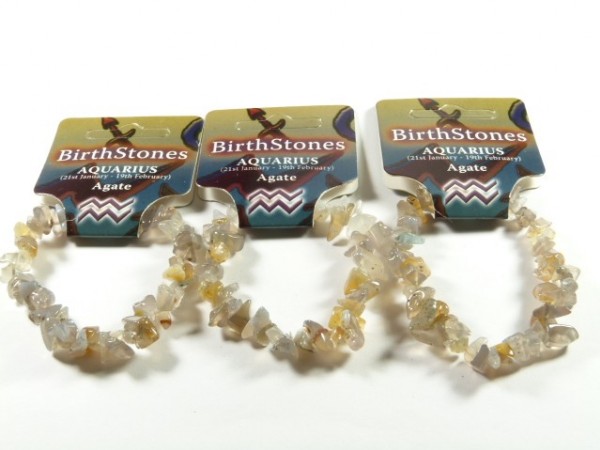 Trzy bransoletki z agatów, przypisane do znaku zodiaku Wodnik, leżą obok siebie.