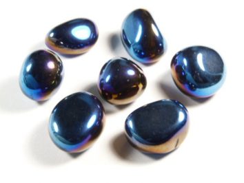 Siedem wypolerowanych, niebiesko-fioletowych kamieni leży na białym tle.