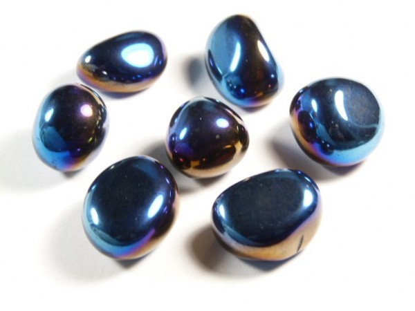 Siedem wypolerowanych, niebiesko-fioletowych kamieni leży na białym tle.