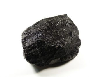 Czarny bryłowy kawałek węgla na białym tle.
