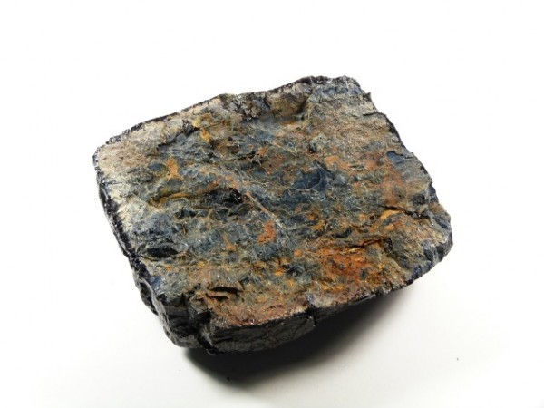 Kawałek rudy żelaza o nieregularnym kształcie na białym tle.