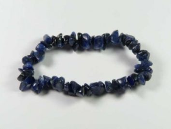 Bransoletka z nieregularnych, niebieskich kamieni na białym tle.