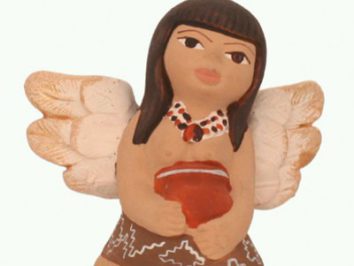 Figurka anioła z ciemnymi włosami, trzymającego czerwone serce, ubrana w brązową spódnicę.