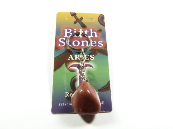 Breloczek z czerwonym kamieniem, opakowanie z napisem "Birth Stones Aries".