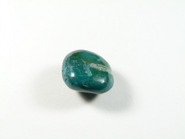 Gładki, niebiesko-zielony kamień leży na białym tle.