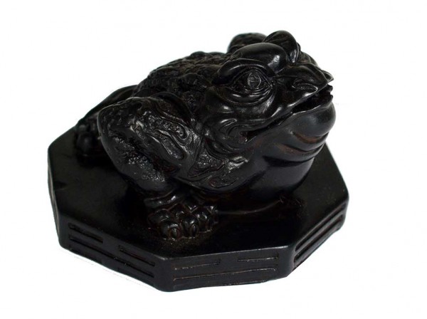 Czarna figurka żaby siedząca na ośmiokątnej podstawce.