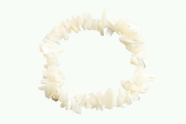 Bransoletka z białych, nieregularnych kamieni na elastycznej gumce, na jasnym tle.