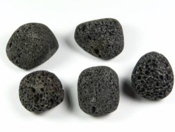 Lawa wulkaniczna - kamień gładzony, polerowany, szlifowany i bębnowany w formie otoczaka. Pięć porowatych, czarnych kamieni jak pumeks na białym tle.