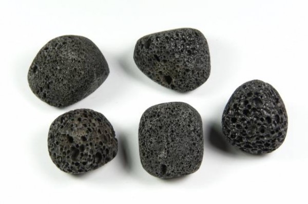 Lawa wulkaniczna - kamień gładzony, polerowany, szlifowany i bębnowany w formie otoczaka. Pięć porowatych, czarnych kamieni jak pumeks na białym tle.