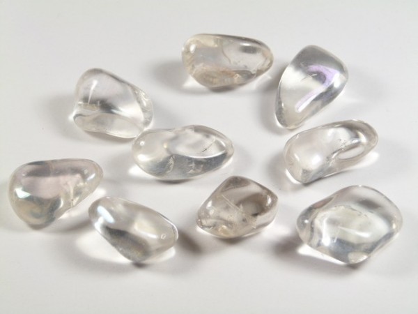 Dziewięć gładkich, przezroczystych kamieni leży na białym tle.