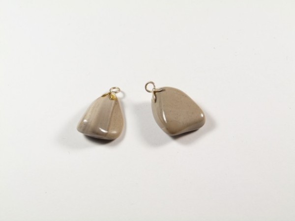 Dwa beżowe wisiorki z kamieni na białym tle, każdy z metalową zawieszką.