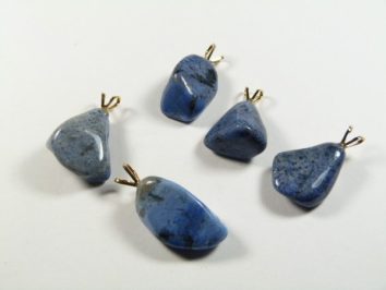 Pięć niebieskich kamieni z zawieszkami na białym tle, przygotowanych na wisiorki.