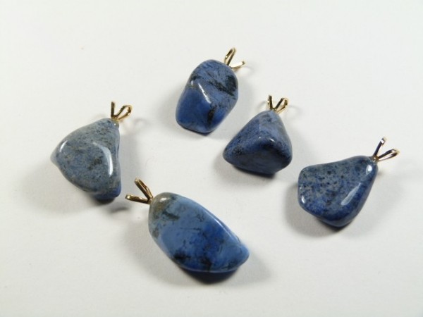 Pięć niebieskich kamieni z zawieszkami na białym tle, przygotowanych na wisiorki.