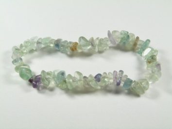 Bransoletka z drobnych, kolorowych kamieni na elastycznej żyłce, leży na białym tle.