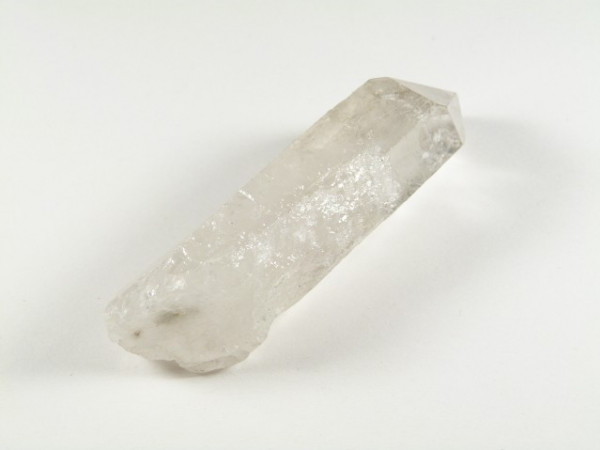 Przezroczysty kryształ kwarcu leżący na białym tle.