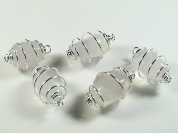 Pięć białych koralików owiniętych srebrnym drutem leży na białym tle.