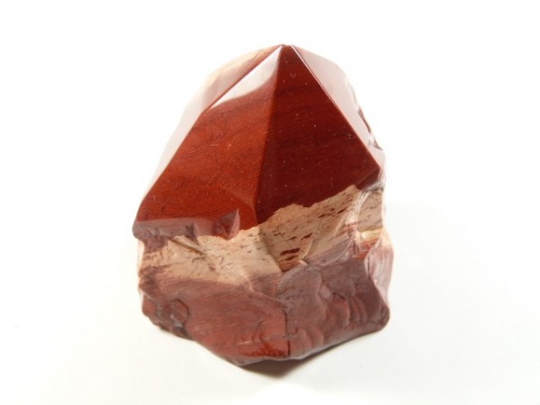 Jaspis skóra węża - kamień okaz częściowo szlifowany, częściowo naturalny. Czerwony, oszlifowany kamień jaspisu na białym tle.