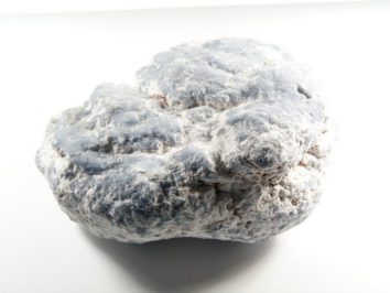 Szara bryła kredy na białym tle.