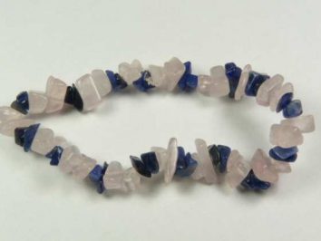 Bransoletka z nieregularnych koralików w kolorze różowym i granatowym, leżąca na białym tle.