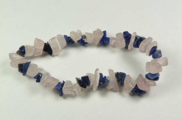 Bransoletka z nieregularnych koralików w kolorze różowym i granatowym, leżąca na białym tle.