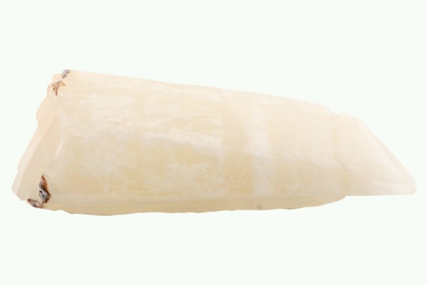 Biały kryształowy kamień, leży na jasnym tle.