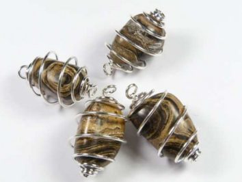 Stromatolit w spirali wisiorek gładzony. Cztery brązowe kamienie owinięte srebrnym drutem, tworzące wiszące zawieszki.